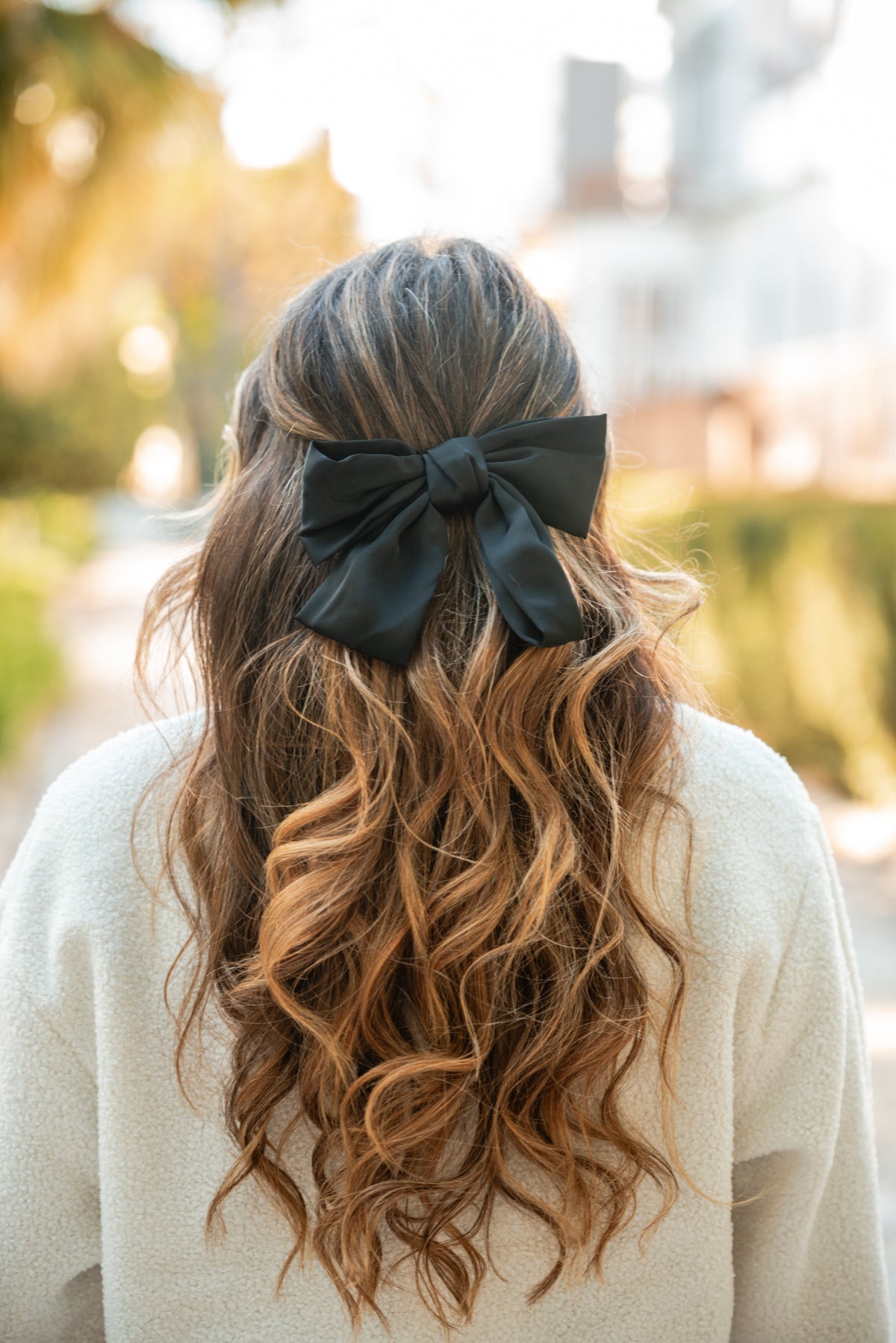 Carmo de costas com o gancho-laço preto em cetim no cabelo