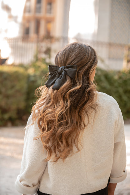 Gancho-laço preto em cetim no cabelo, visto de mais longe